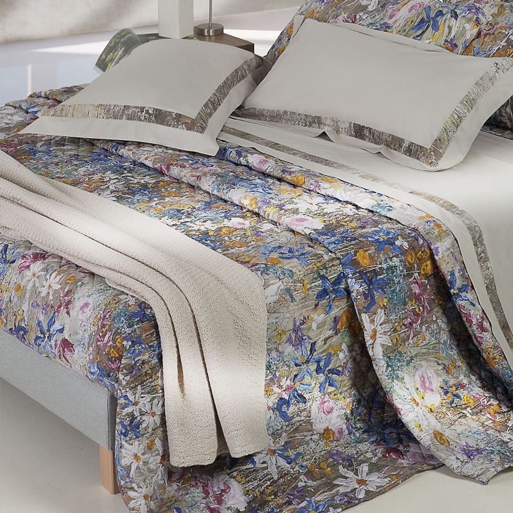 Trapunta a fiori e guanciali su un letto