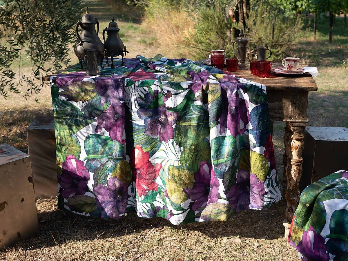 Tovaglia a fiori su un tavolo da giardino, fra gli ulivi