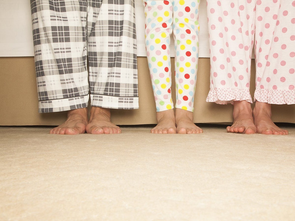 Tre persone in pigiama, inquadrate dalle gambe in giù