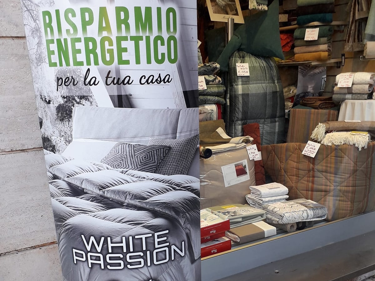 Totem promozionale di un piumino davanti alla vetrina del negozio