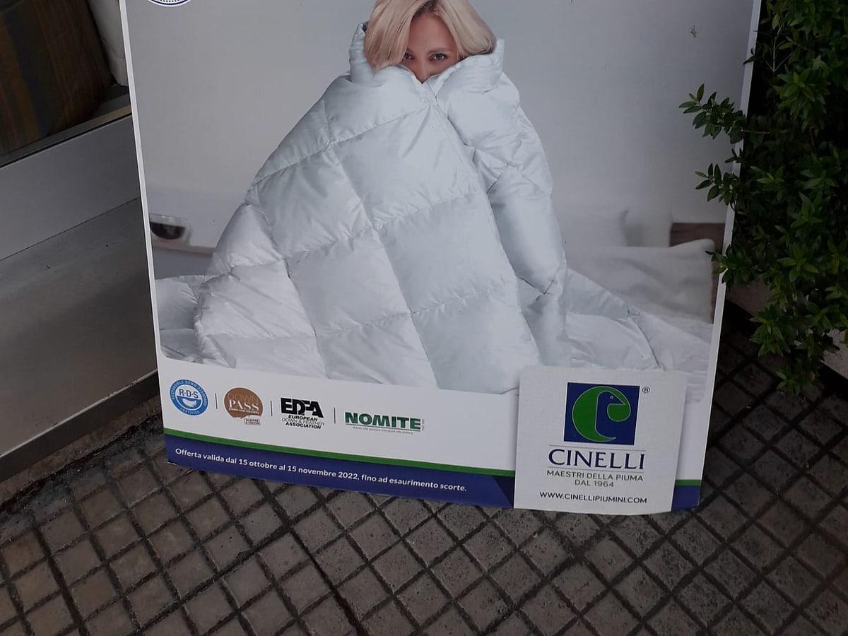 Totem promozionale di un piumino davanti all'ingresso del negozio