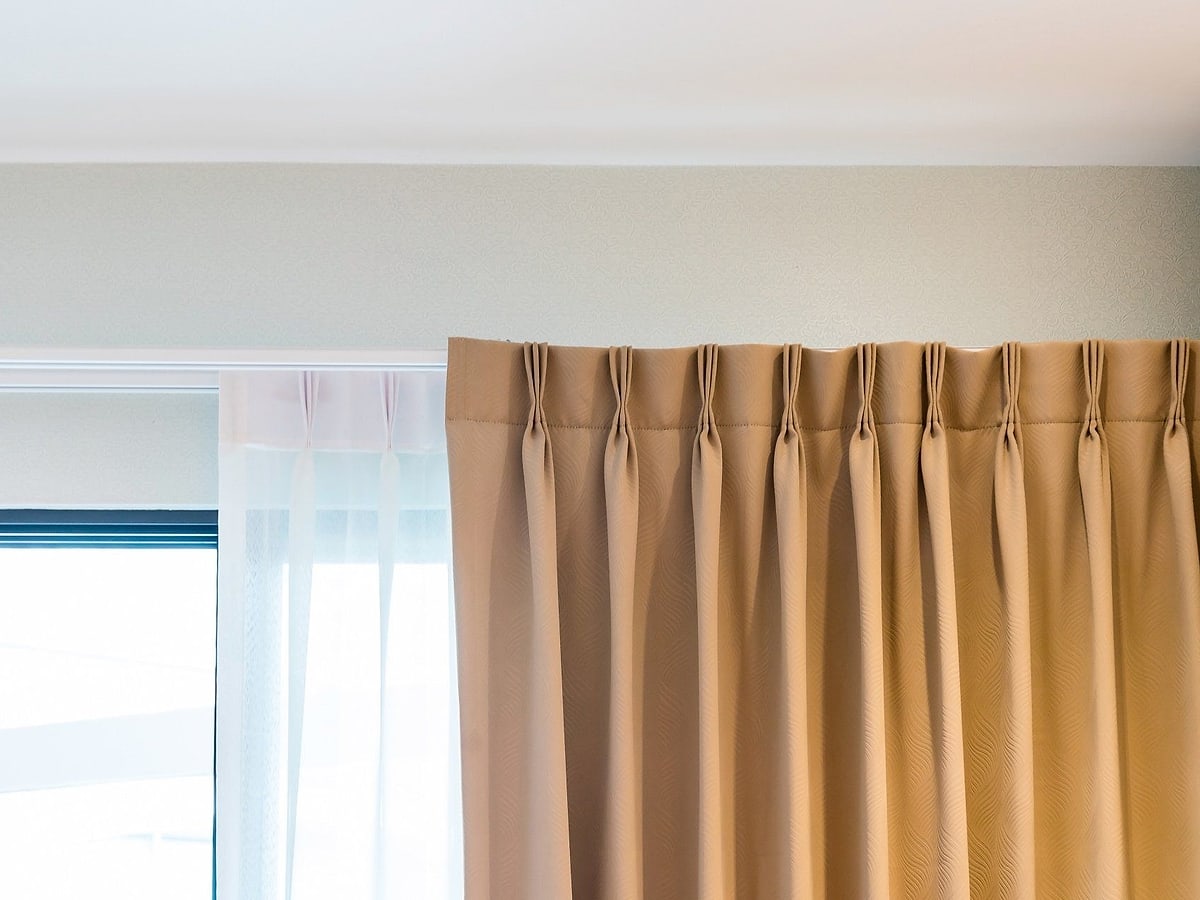 Tenda beige a pieghe con tendina bianca sotto